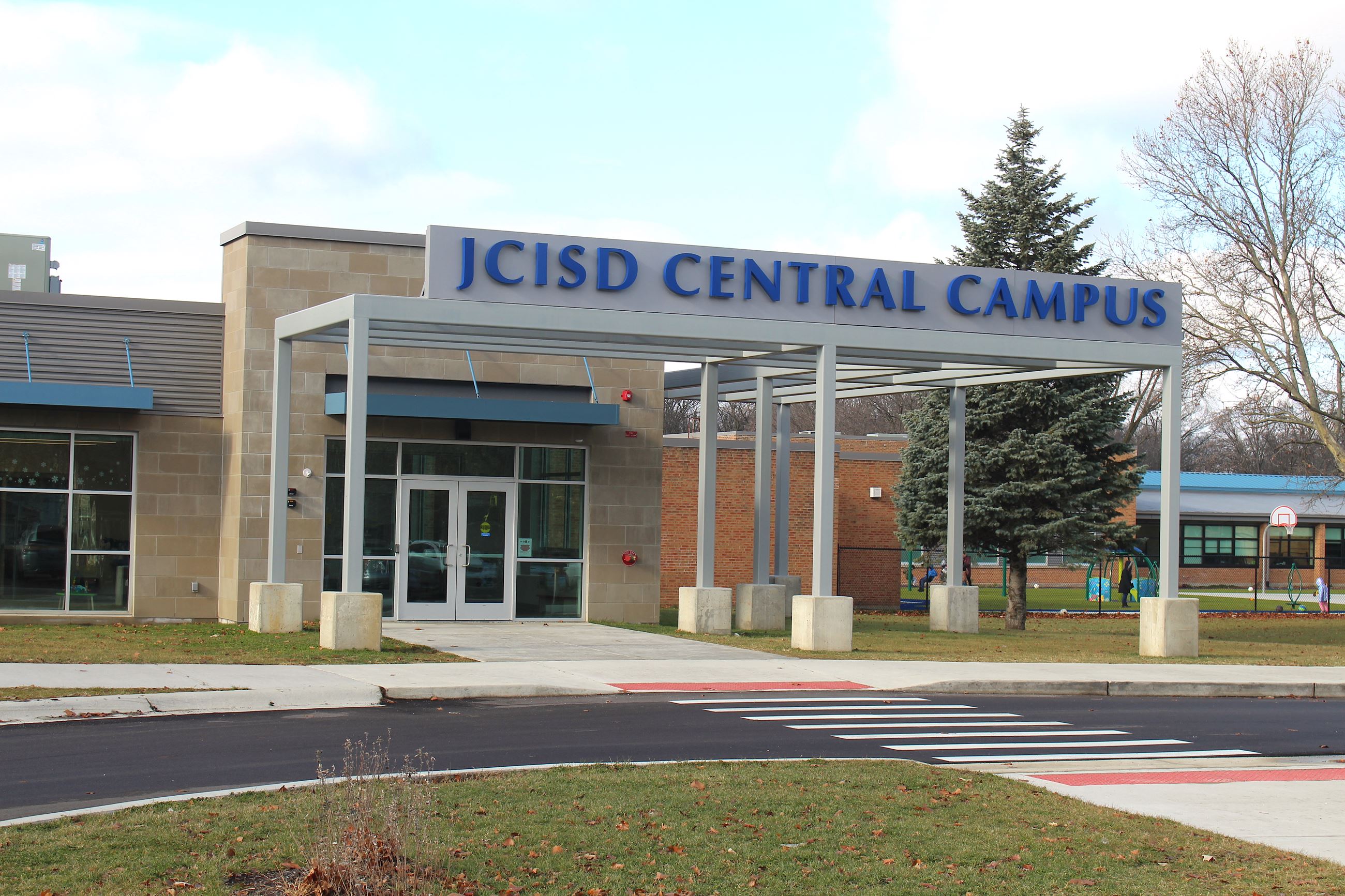Front entrance of a school building with a sign that says JCISD Central Campus 