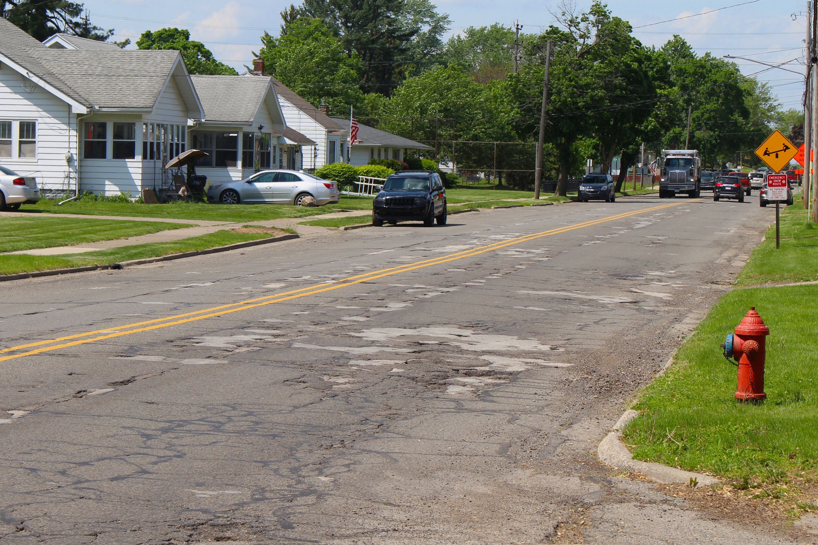 A street with homes and potholes 