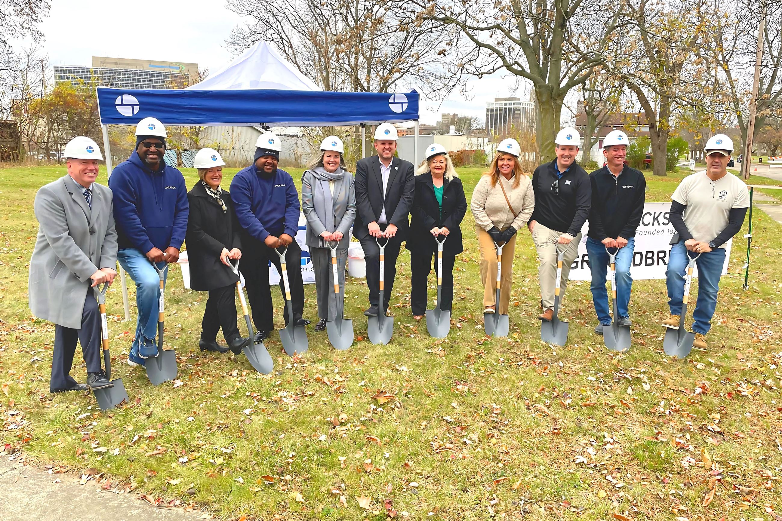 A group of people pose for a photo with shovels 