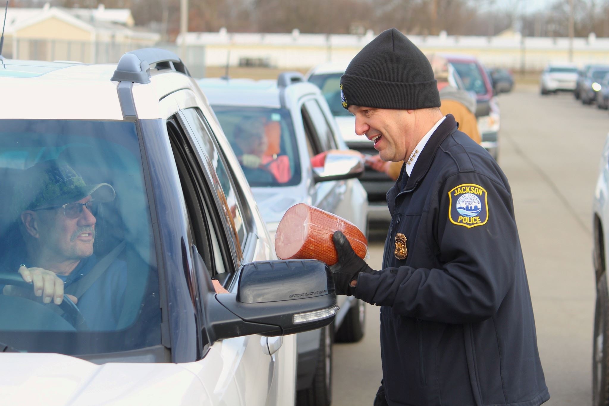 2023 Ham Drive Thru event. JPD Director Elmer Hitt gives ham to resident